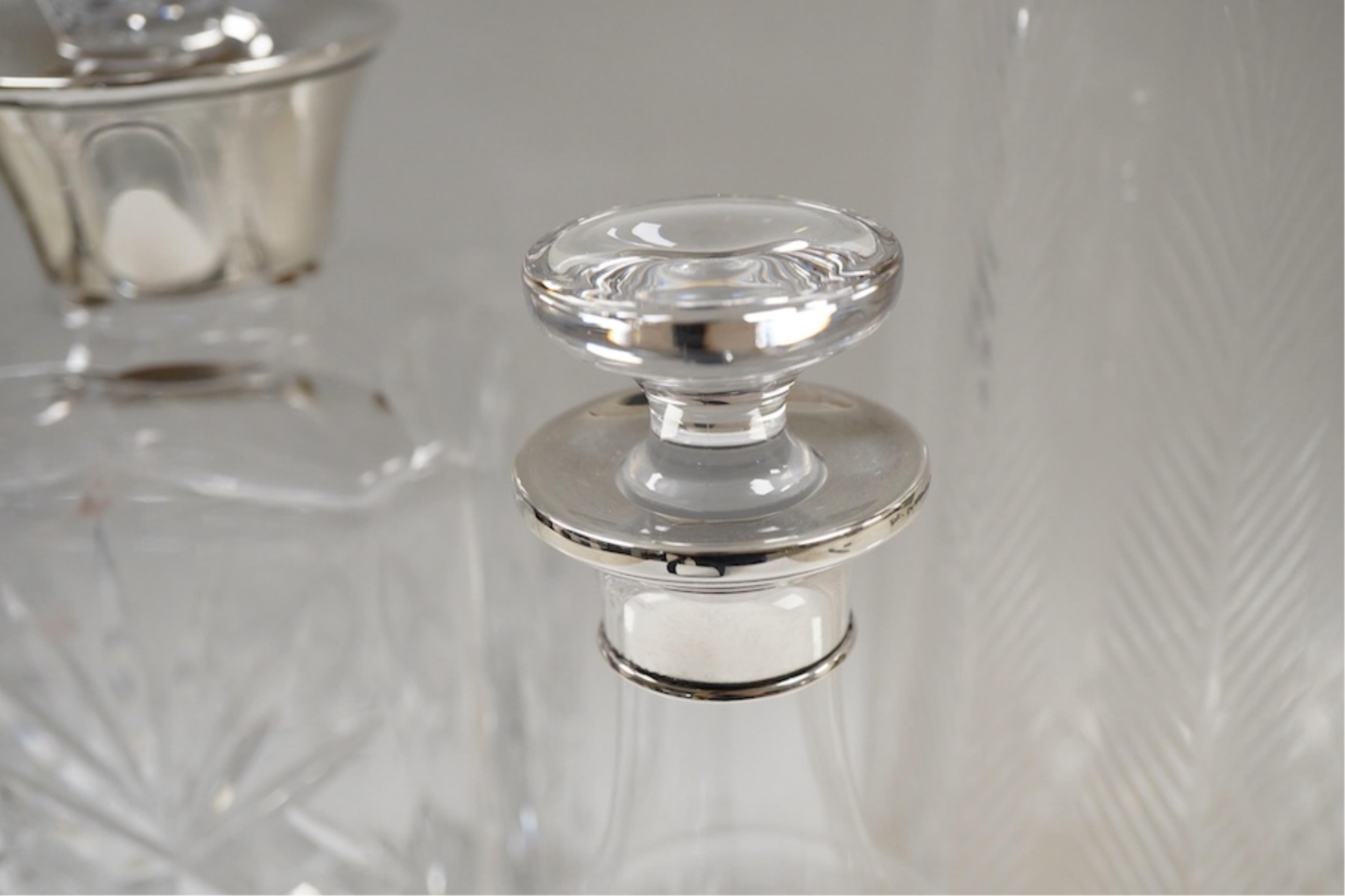 Three assorted silver mounted cut glass decanters, including two modern and one earlier with lock, marks rubbed, no key, the latter 34.1cm.